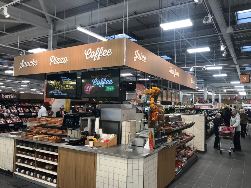 Interior of a supermarket with signage.