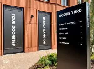 black "GOODS YARD" directional sign with white text and arrows