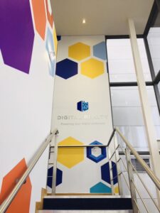 Digital Realty office wall graphic with hexagonal pattern and logo above stairs