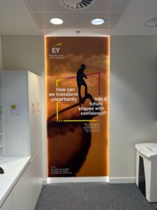 EY Head Office illuminated wall graphic with silhouette and inspirational text