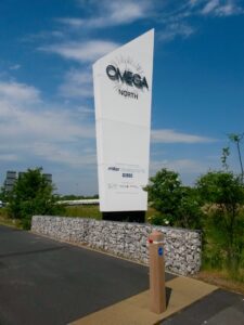 A large, white, angular totem for 'OMEGA NORTH'