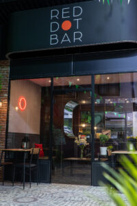 The "RED DOT BAR" storefront features a black facade with white text