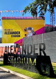 Large 'ALEXANDER STADIUM' sign in front of a banner for the Birmingham 2022 Commonwealth Games.